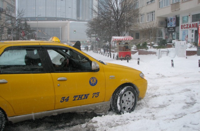 Istanbul Taksi trying to pass an intersection on a snowy road