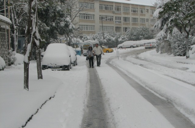 A couple walking in the middle of the road.