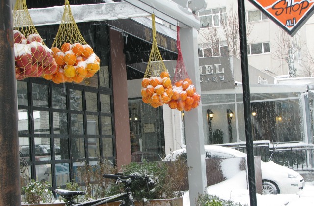 Oranges covered with snow at one of the shops which serves orange juice.