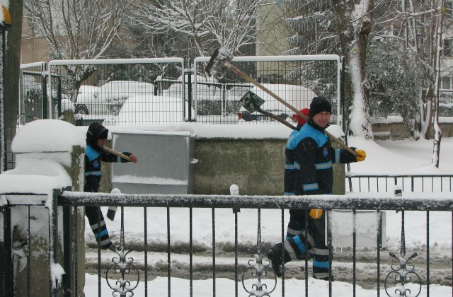 Municipality workers with shovels on their shoulders are all ready for cleaning up the snow.