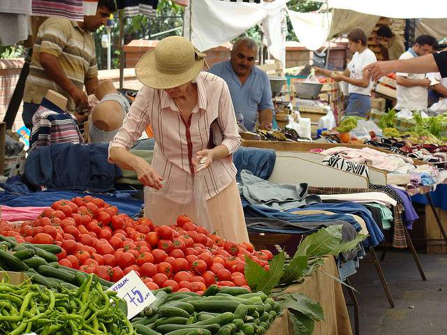 Lady shopping for tomatoes at a public market in Istanbul